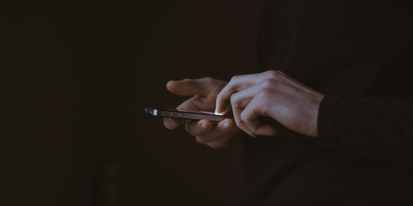 silhouette photo of person holding smartphone