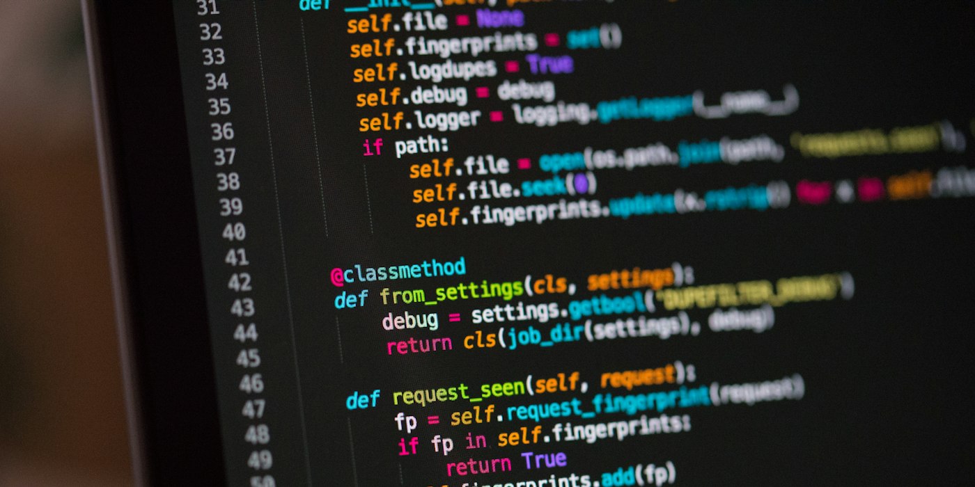 A dark monitor showing lines of colour-highlighted code